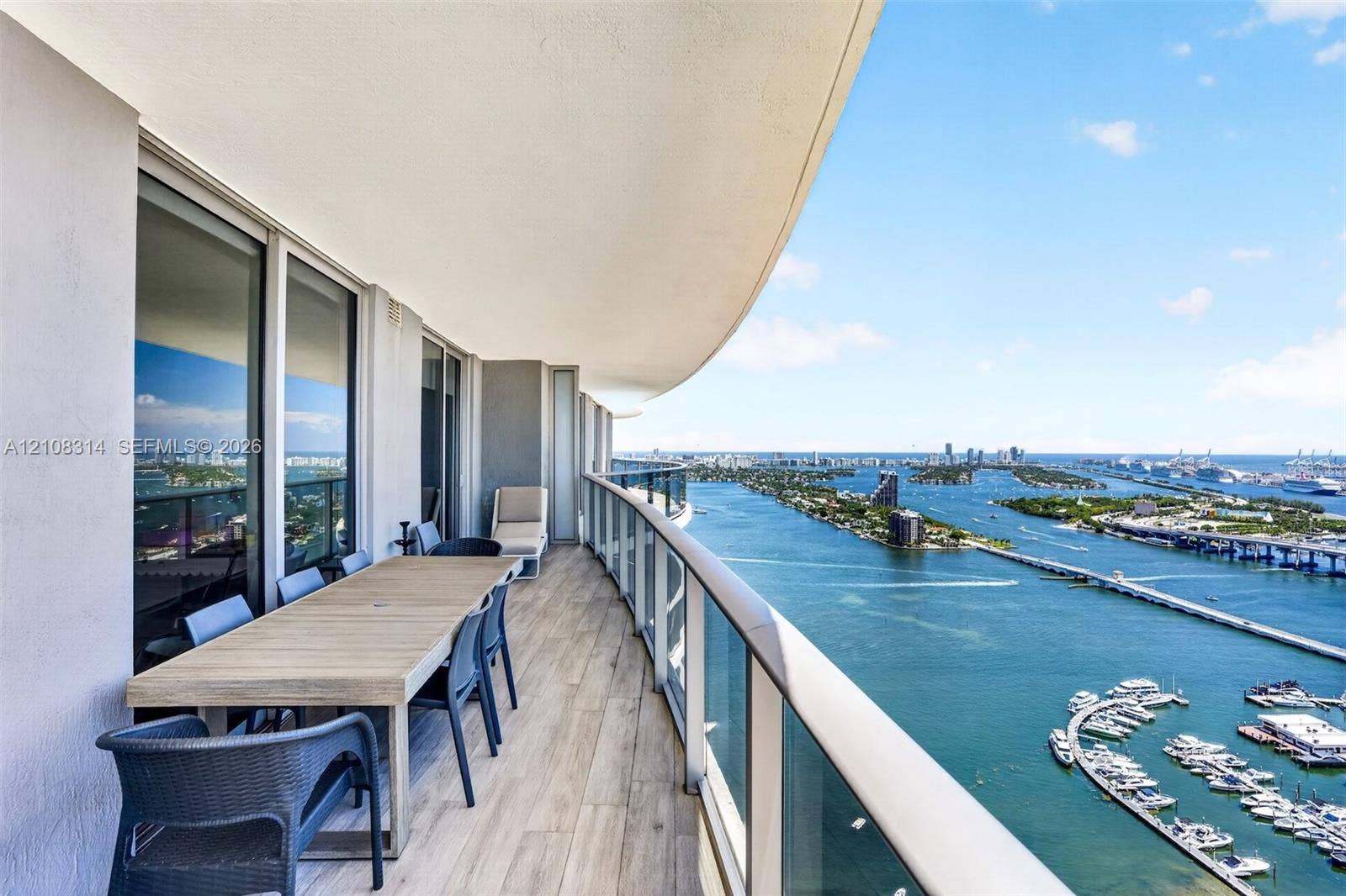 488 NE 18th Street, #4010, Miami, FL 33132 Expansive covered balcony featuring wood-finish tile flooring and a glass panel railing