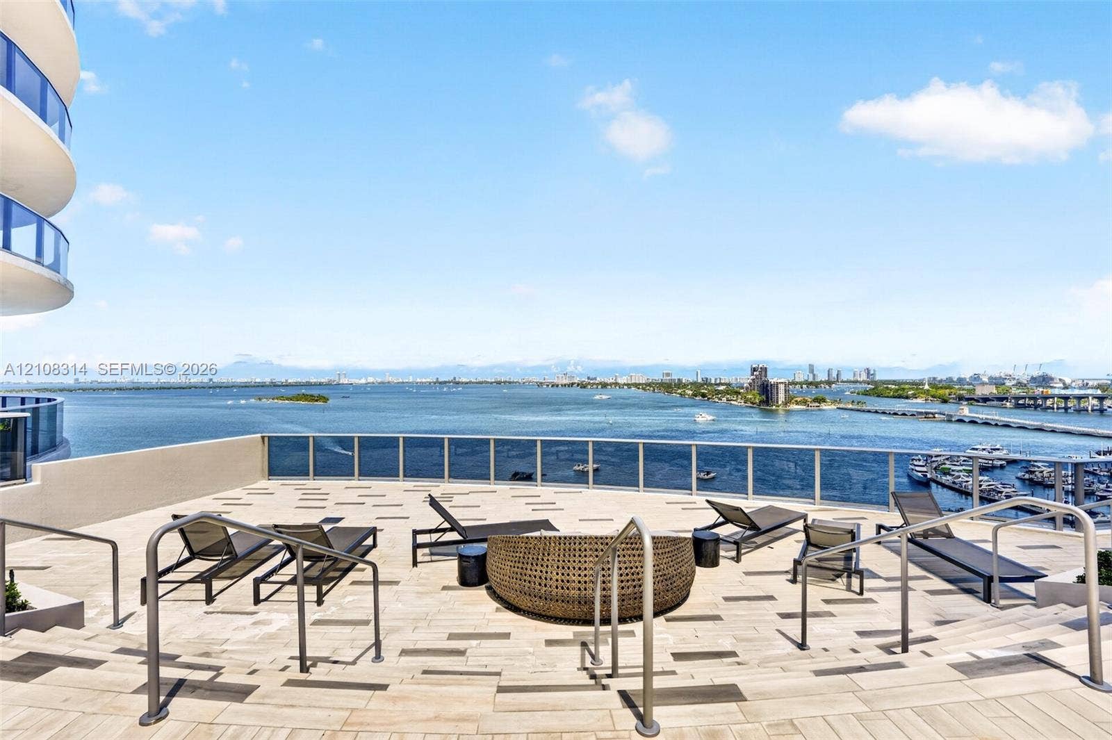 488 NE 18th Street, #4010, Miami, FL 33132 Expansive rooftop terrace featuring patterned stone-finish flooring, metal railing, and multi-level stepped access