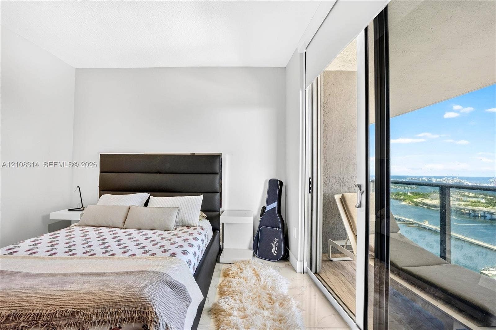 488 NE 18th Street, #4010, Miami, FL 33132 Floor-to-ceiling sliding glass door, private balcony with metal railing, and light-toned tile flooring