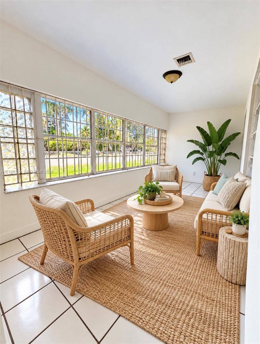 722 NW 7th Avenue, Homestead, FL 33030 Enclosed space featuring large, grid-patterned casement windows, white ceramic tile flooring, and a flush-mount ceiling fixture