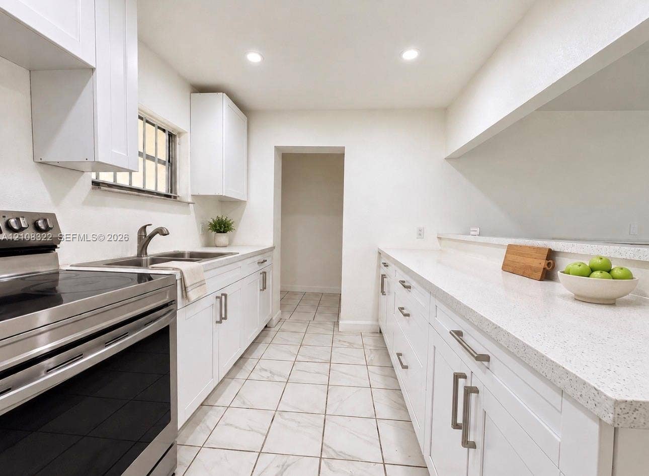 722 NW 7th Avenue, Homestead, FL 33030 Kitchen featuring white shaker-style cabinetry, light-toned stone countertops, stainless steel range, and tile flooring