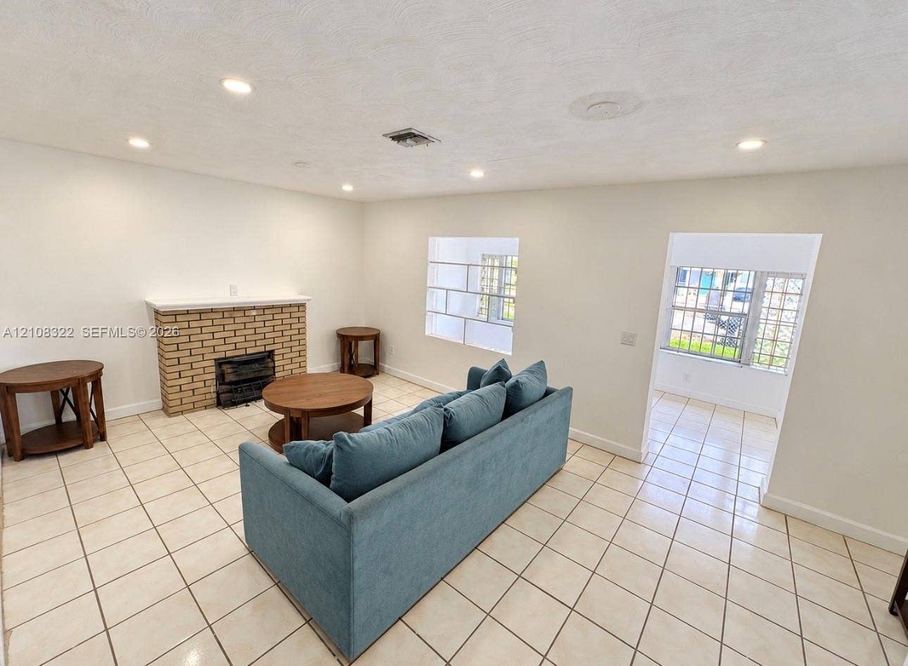 722 NW 7th Avenue, Homestead, FL 33030 Brick fireplace with a mantel, grid-pattern window, recessed lighting, and tile flooring
