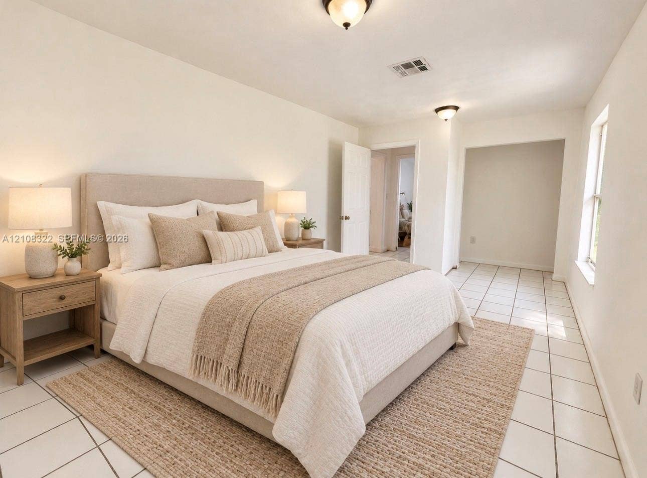 722 NW 7th Avenue, Homestead, FL 33030 Neutral-toned interior space featuring light-colored ceramic tile flooring, dual flush-mount ceiling light fixtures, and natural light via a single-pane window