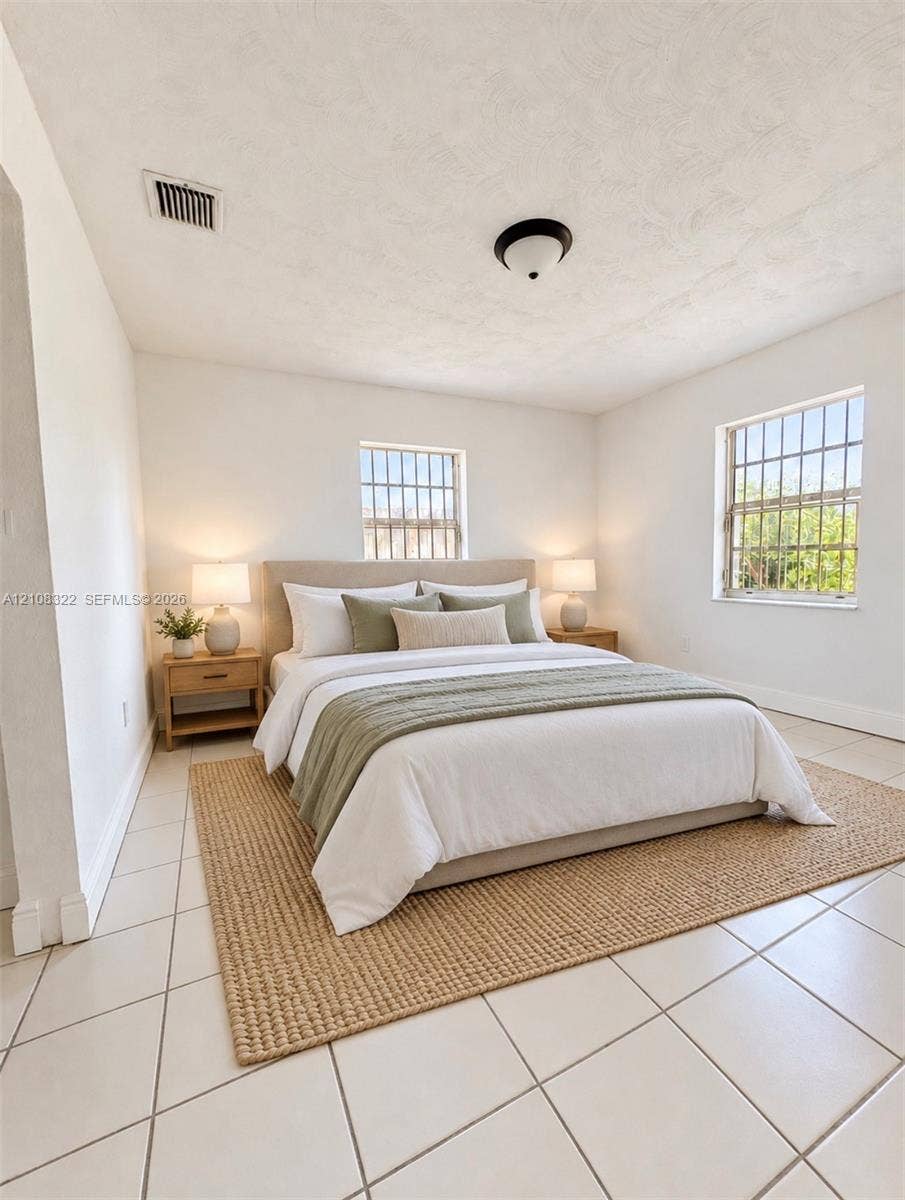 722 NW 7th Avenue, Homestead, FL 33030 Interior space featuring neutral wall tones, large-format ceramic tile flooring, and dual windows with security bars
