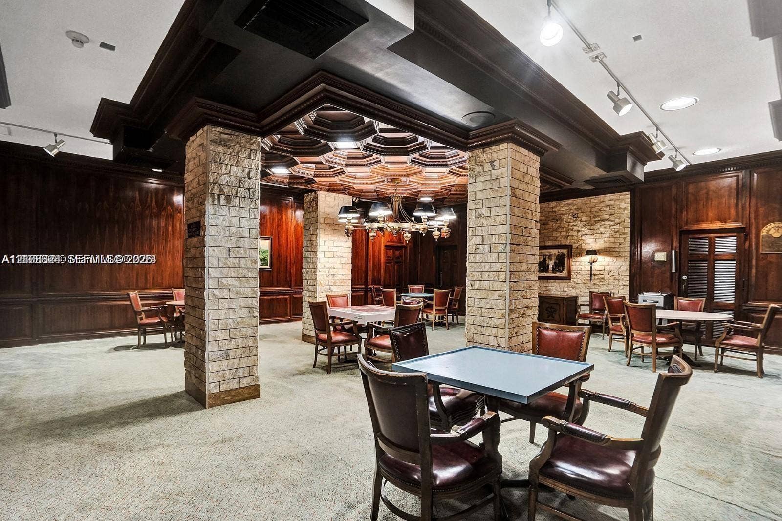 6039 Collins Avenue, #1208, Miami Beach, FL 33140 Custom coffered wood ceiling, stone-clad structural columns, rich wood-paneling, and integrated track lighting