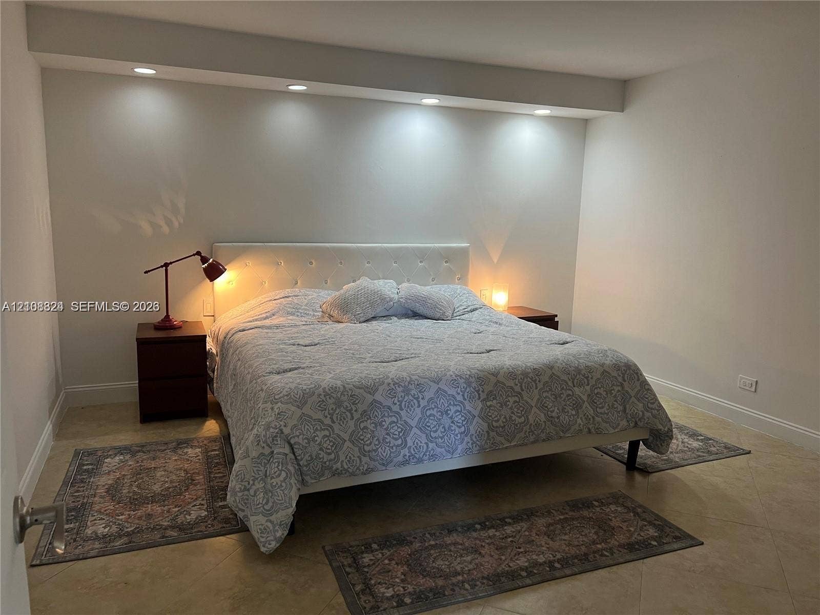 6039 Collins Avenue, #1208, Miami Beach, FL 33140 Neutral-toned interior featuring large-format tile flooring and an architectural soffit with recessed downlighting