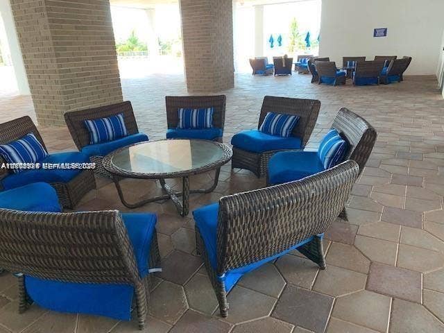 6039 Collins Avenue, #1208, Miami Beach, FL 33140 Covered patio featuring large-format stone pavers and structural masonry pillars