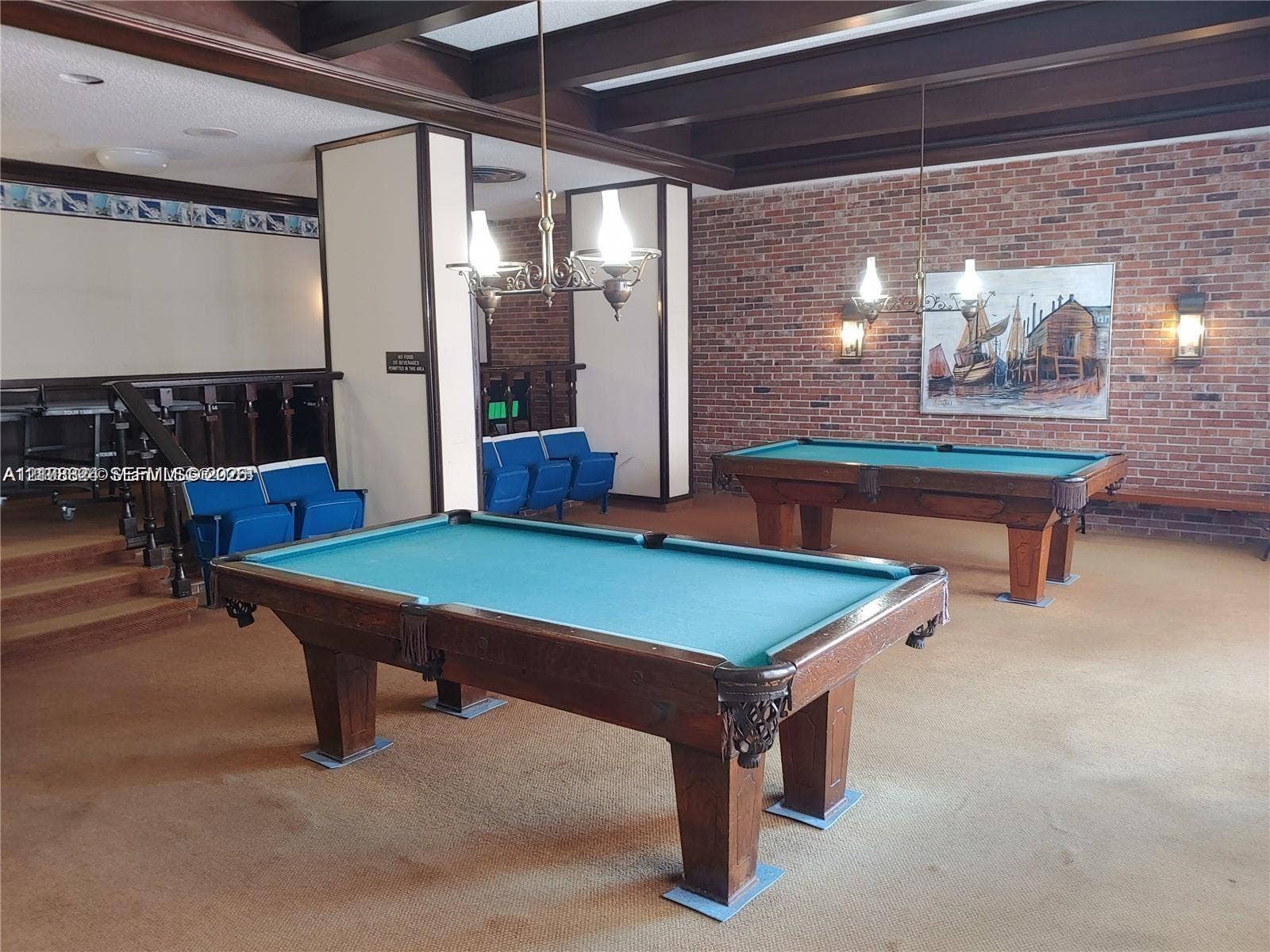 6039 Collins Avenue, #1208, Miami Beach, FL 33140 Exposed wood ceiling beams, floor-to-ceiling brick wall, and decorative hanging light fixtures