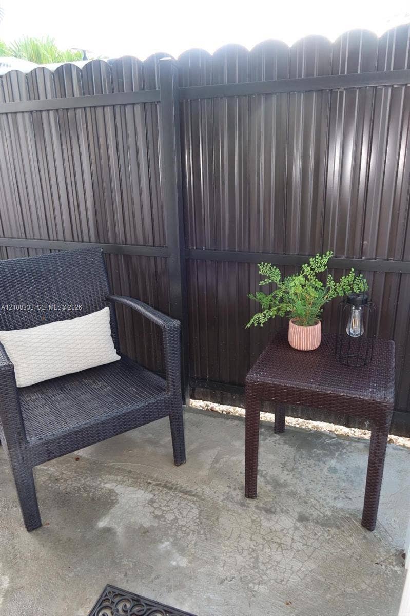 10450 SW 166th Terrace, #0, Miami, Miami, FL 33157 Concrete patio enclosed by a dark-finished scalloped privacy fence