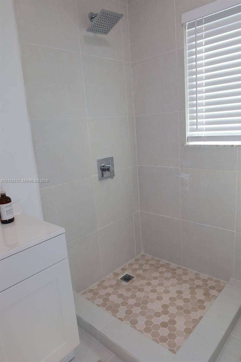 10450 SW 166th Terrace, #0, Miami, Miami, FL 33157 Walk-in shower featuring large-format wall tile, hexagonal floor tiling, a square rainfall showerhead, and a single-handle chrome fixture