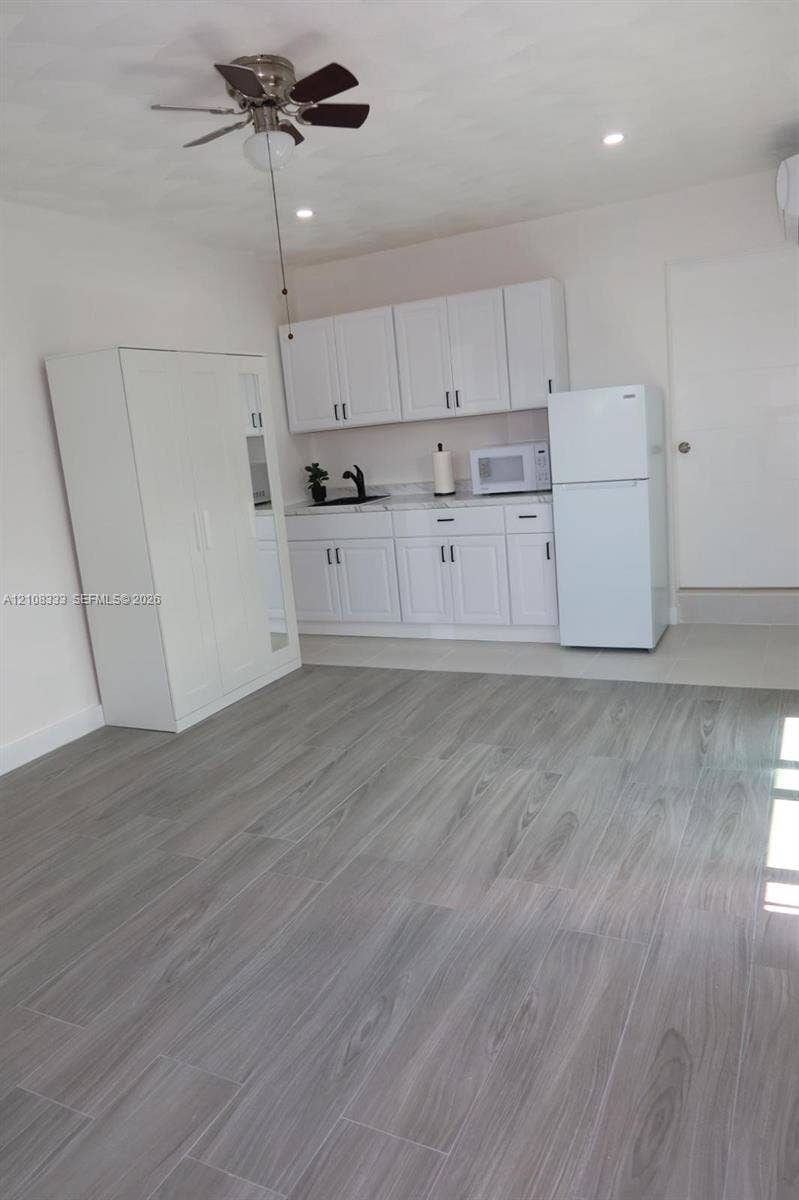 10450 SW 166th Terrace, #0, Miami, Miami, FL 33157 Kitchenette featuring white cabinetry, wood-finish tile flooring, a matte black faucet, and a ceiling fan with integrated lighting