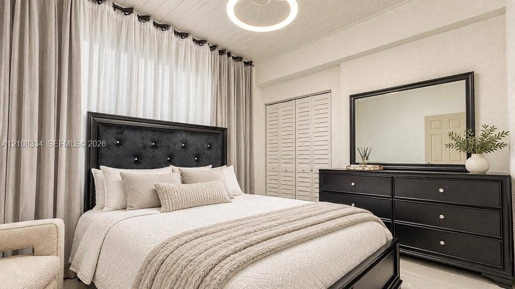 Beadboard ceiling featuring a circular flush-mount light fixture and floor-to-ceiling drapery window treatment with louvered-style bi-fold closet doors