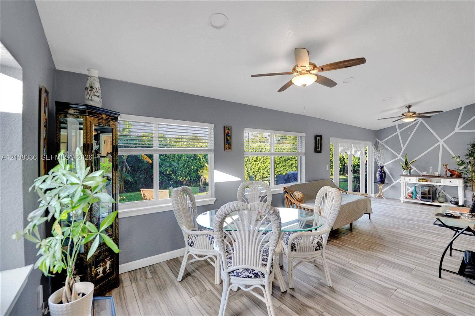 6311 Hitchin Post Way, Delray Beach, FL 33484 Open-concept room featuring wood-finish flooring, recessed lighting, dual ceiling fans, geometric wall detailing, and expansive windows