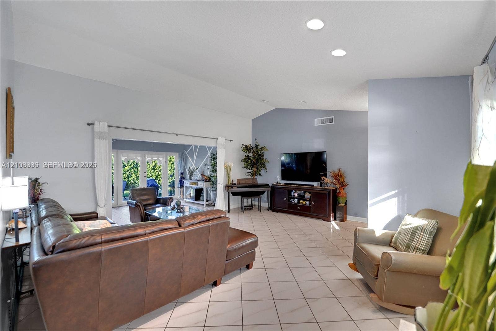 6311 Hitchin Post Way, Delray Beach, FL 33484 Living area featuring vaulted ceilings, recessed lighting, tile flooring, and French doors