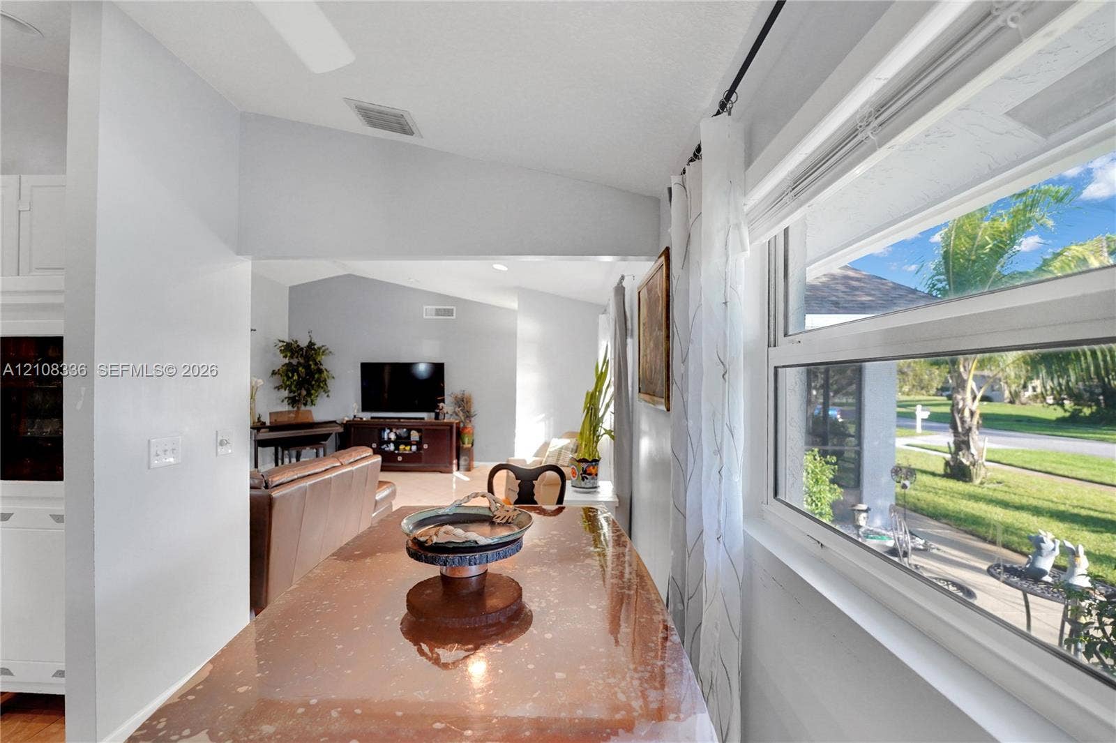 6311 Hitchin Post Way, Delray Beach, FL 33484 Vaulted ceilings, large picture window with natural light, and neutral wall color palette