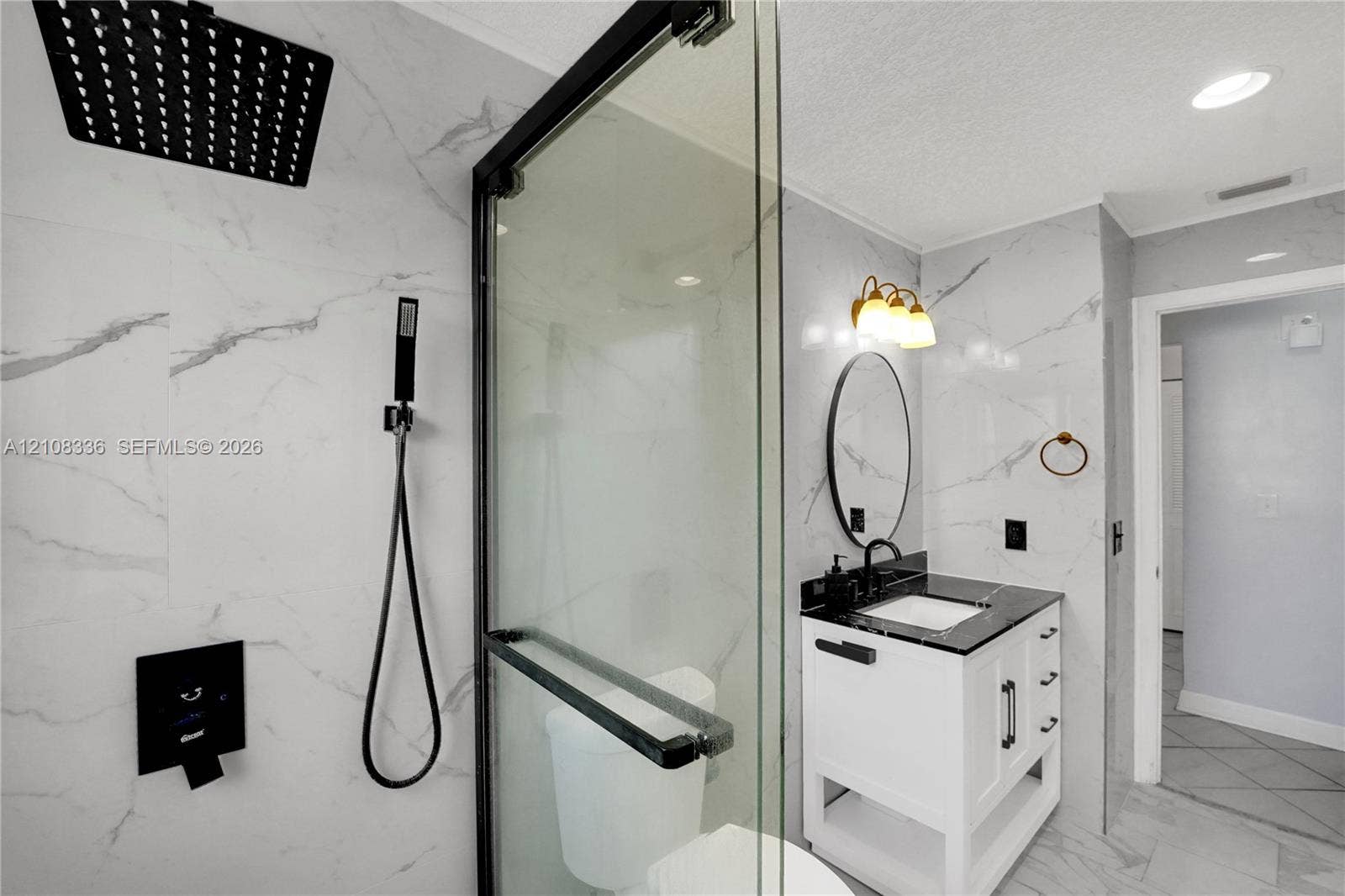 6311 Hitchin Post Way, Delray Beach, FL 33484 Walk-in shower featuring floor-to-ceiling stone-pattern tile, a rainfall showerhead with handheld attachment, and a black-framed glass enclosure