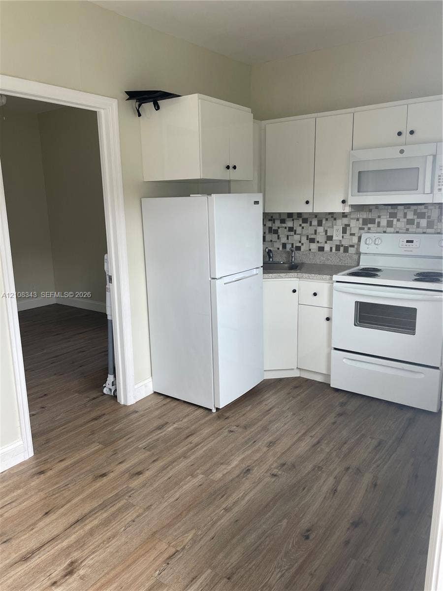1935 Liberty Street, #3, Hollywood, Hollywood, FL 33020 Kitchen featuring white cabinetry, wood-finish flooring, multi-tonal mosaic tile backsplash, and white built-in appliances