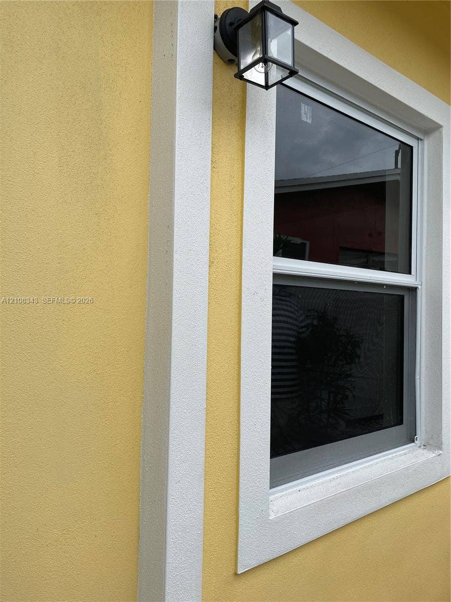 1935 Liberty Street, #3, Hollywood, Hollywood, FL 33020 Textured exterior stucco finish with white trim framing and attached outdoor lantern-style light fixture