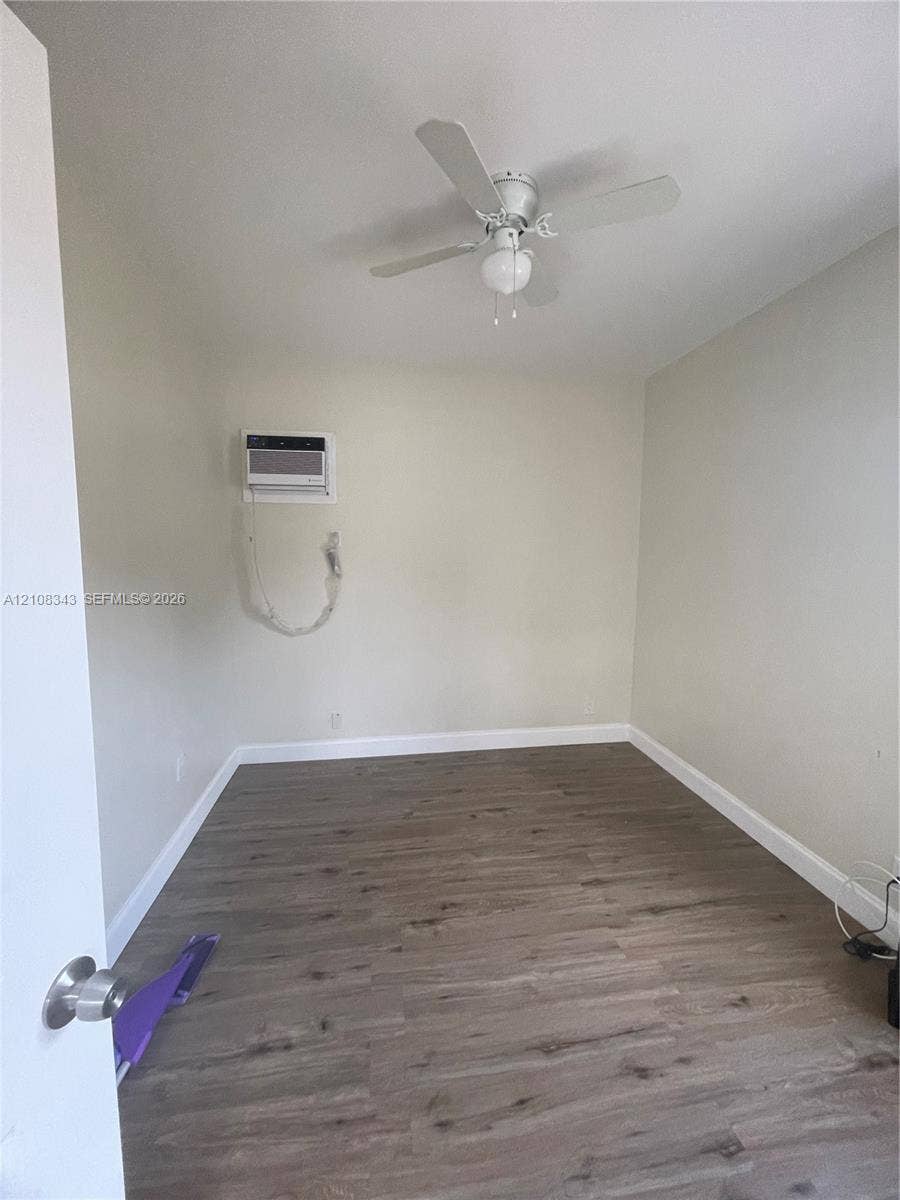 1935 Liberty Street, #3, Hollywood, Hollywood, FL 33020 Room featuring wood-finish flooring, a white ceiling fan with integrated lighting, and a wall-mounted air conditioning unit