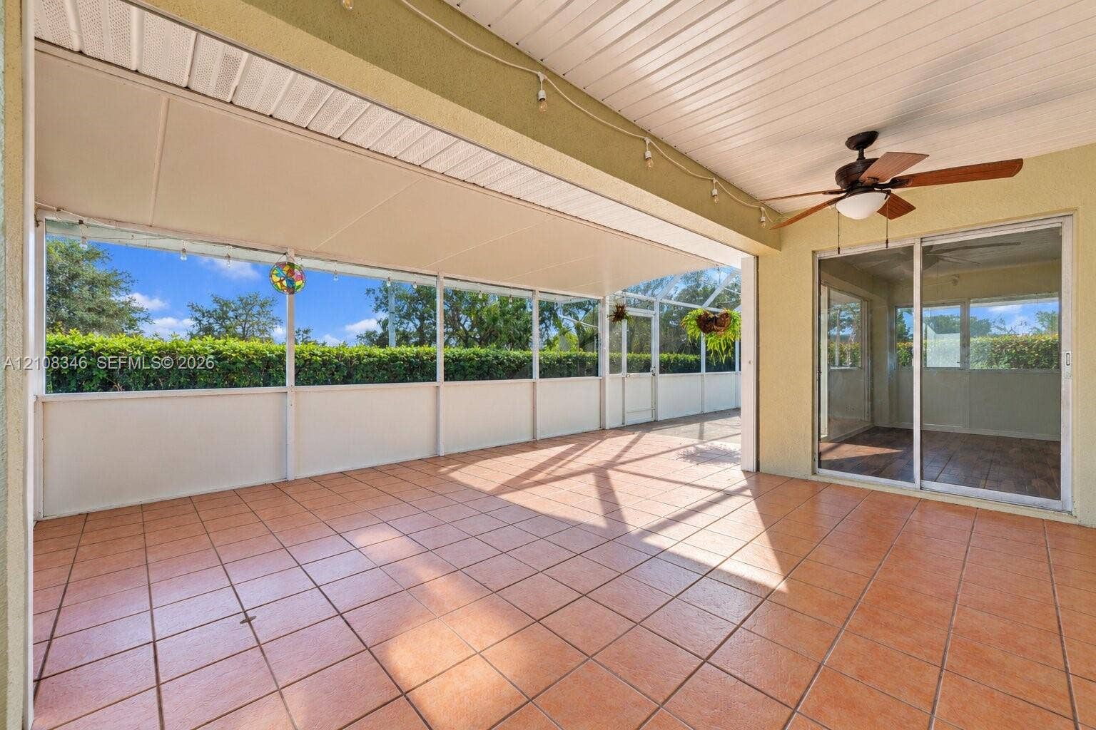 2530 SE 7th Place, Homestead, FL 33033 Screened-in lanai featuring ceramic tile flooring, a white paneled ceiling, a ceiling fan, and sliding glass door access