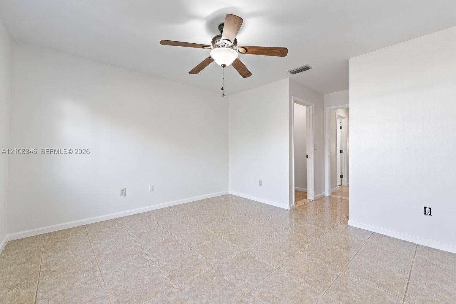 2530 SE 7th Place, Homestead, FL 33033 Neutral-toned tile flooring, white wall finish, and a ceiling-mounted fan with integrated light fixture