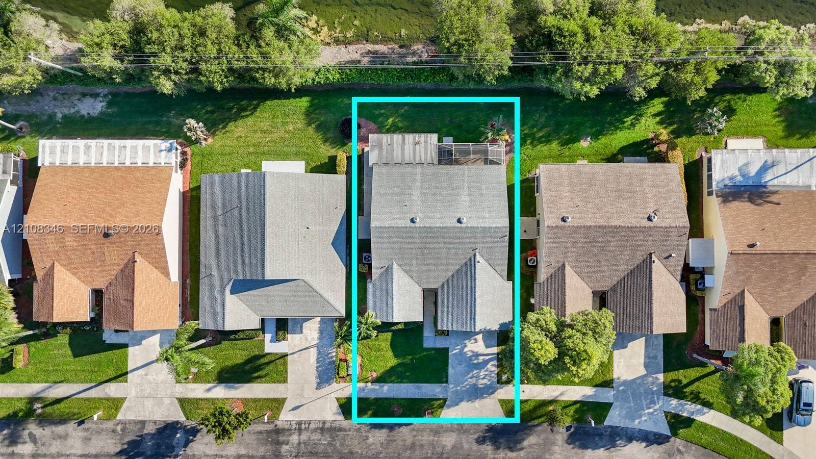 2530 SE 7th Place, Homestead, FL 33033 Aerial perspective of the property featuring a paved driveway, a multi-gabled roofline, and a rear screened-in enclosure