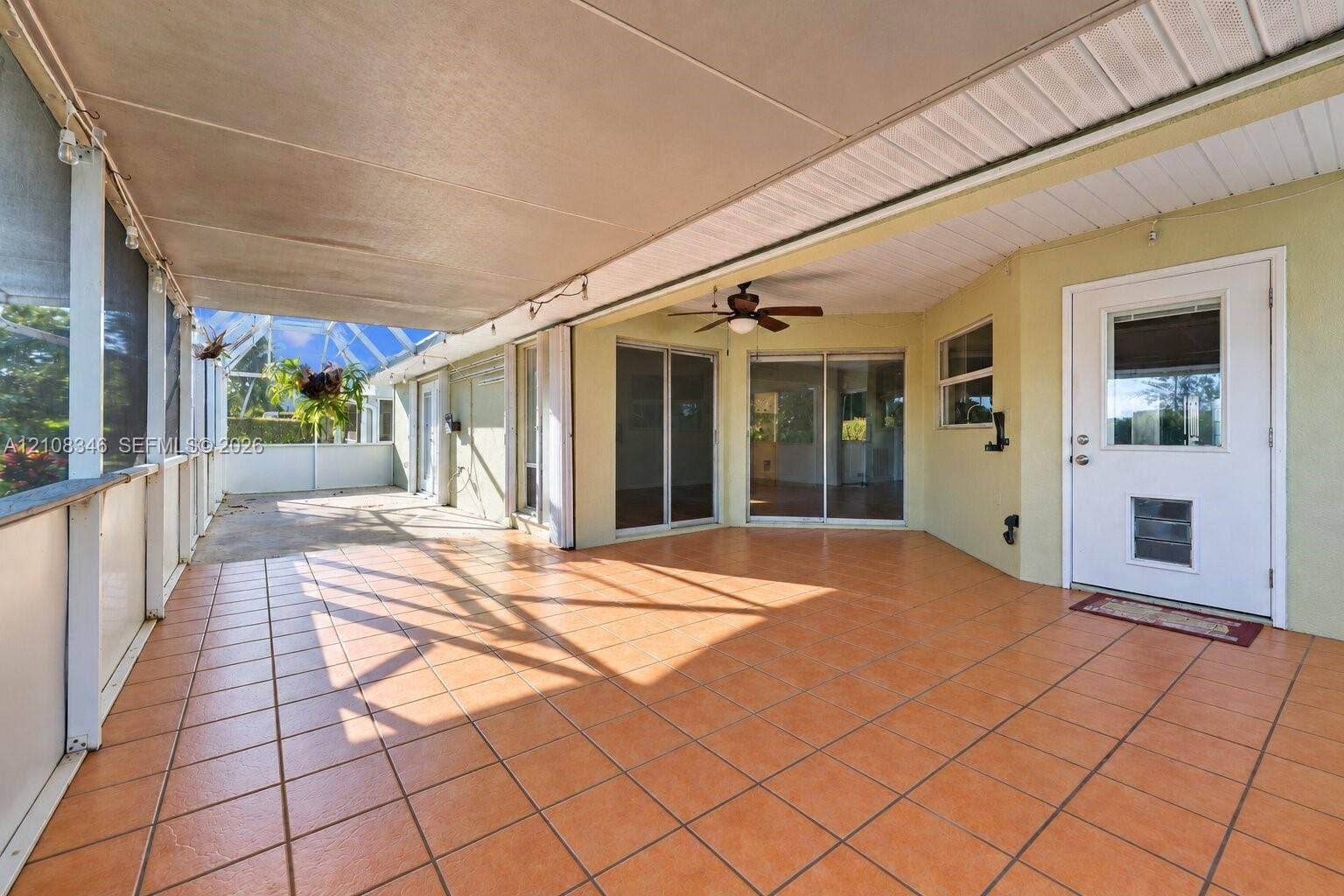2530 SE 7th Place, Homestead, FL 33033 Screened-in lanai featuring ceramic tile flooring, a solid roof cover, a ceiling fan, and sliding glass door entry