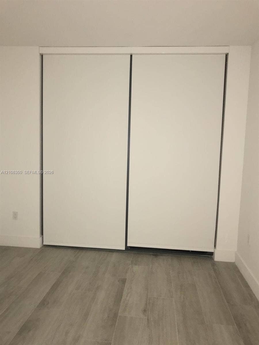 121 NE 34th Street, #1403, Miami, Miami, FL 33137 Sliding closet with white panel doors and wood-finish flooring