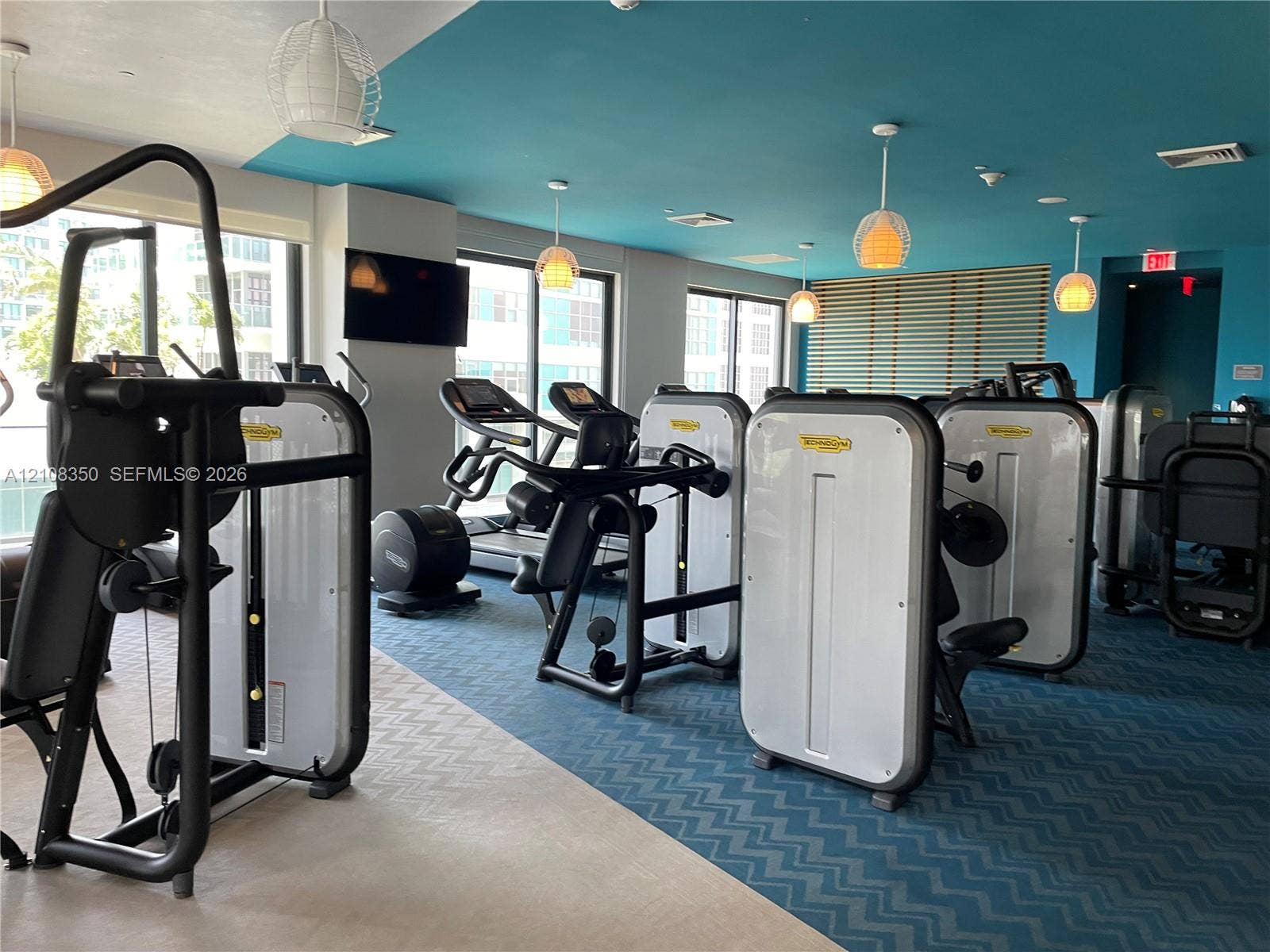 121 NE 34th Street, #1403, Miami, Miami, FL 33137 Fitness center featuring a variety of professional-grade exercise equipment, geometric patterned carpet, recessed and pendant lighting, and floor-to-ceiling windows