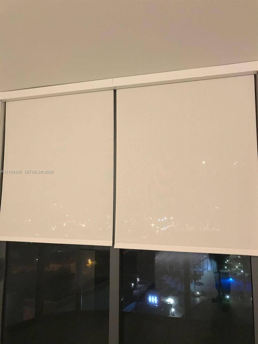 121 NE 34th Street, #1403, Miami, Miami, FL 33137 Floor-to-ceiling windows featuring dual-pane glazing, dark-finish metal frames, and integrated retractable roller shades