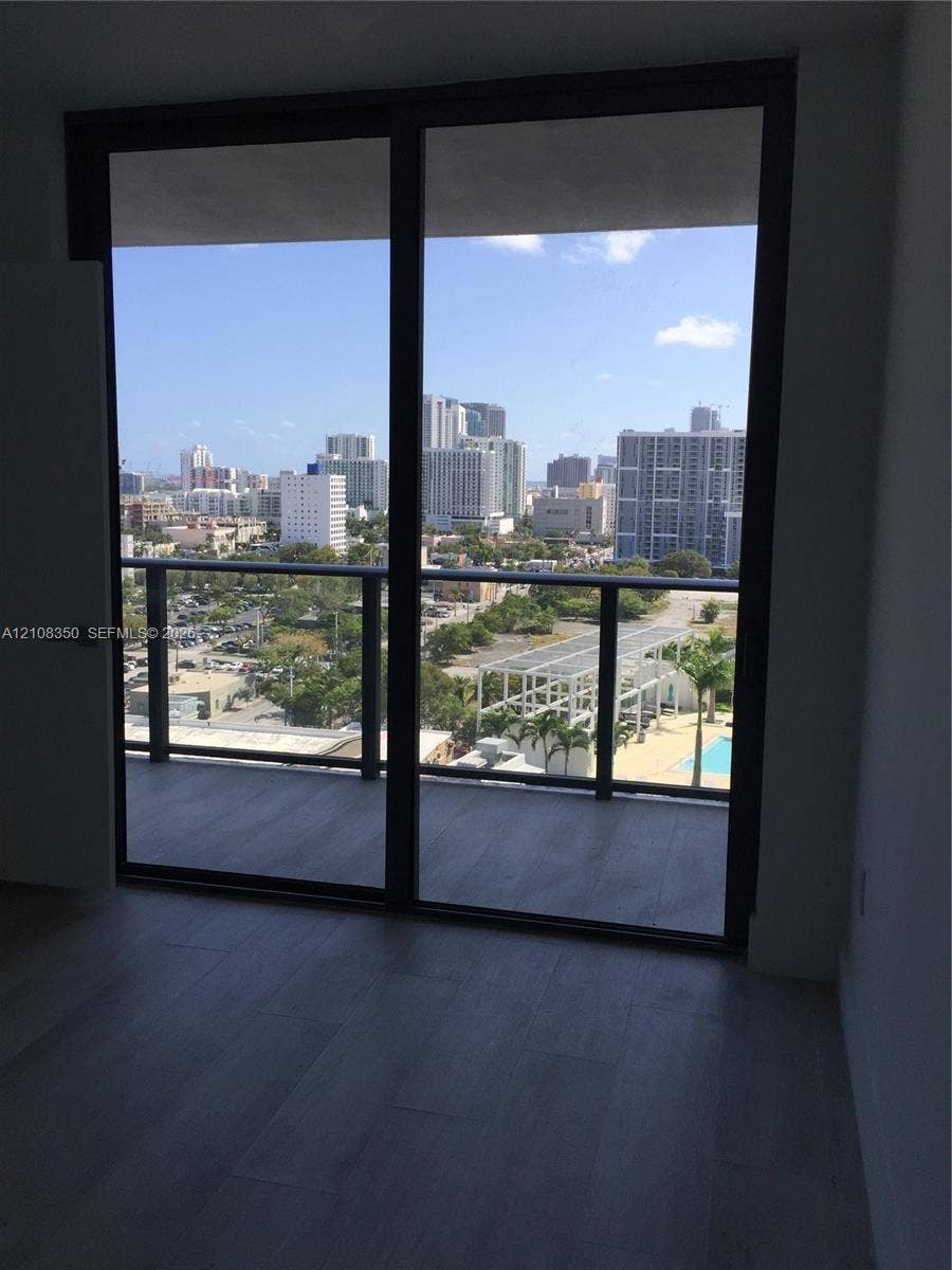 121 NE 34th Street, #1403, Miami, Miami, FL 33137 Floor-to-ceiling glass panel windows with metal framing and wood-finish flooring