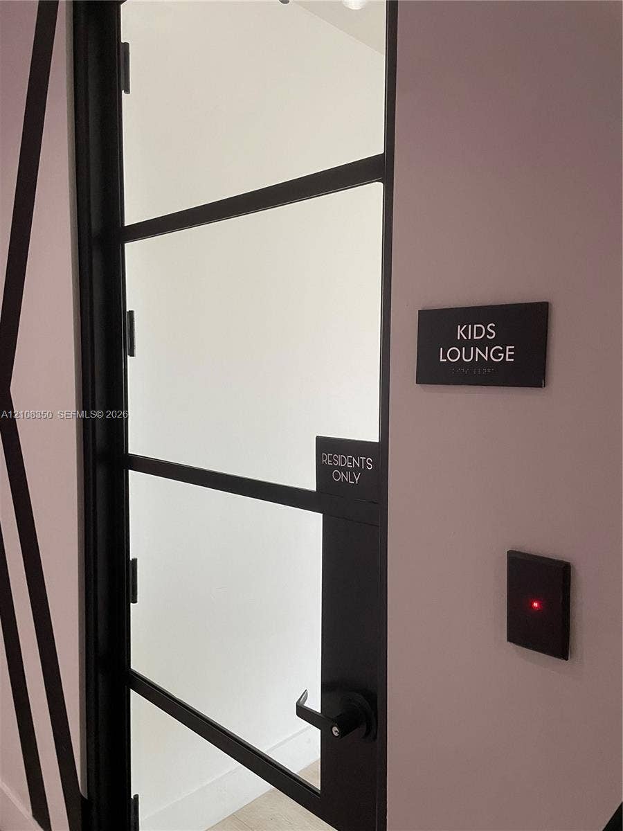 121 NE 34th Street, #1403, Miami, Miami, FL 33137 Black-framed glass door with metal lever handle and electronic access control