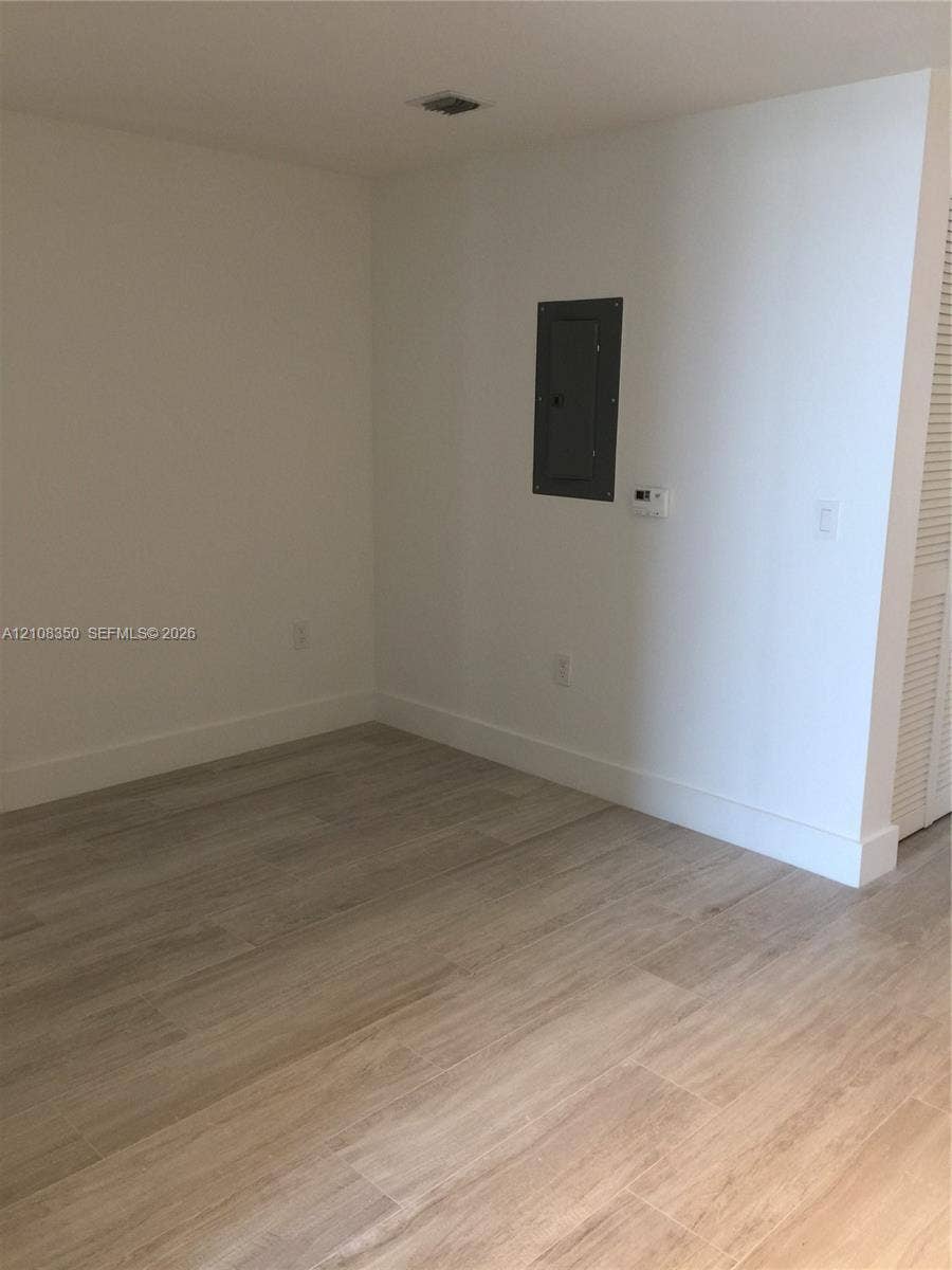 121 NE 34th Street, #1403, Miami, Miami, FL 33137 Neutral interior space featuring wood-finish flooring and louvered closet doors