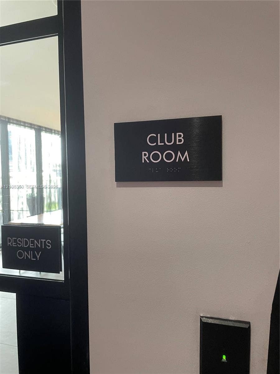 121 NE 34th Street, #1403, Miami, Miami, FL 33137 Club room entrance featuring a black signage panel with braille and a secure electronic access control system