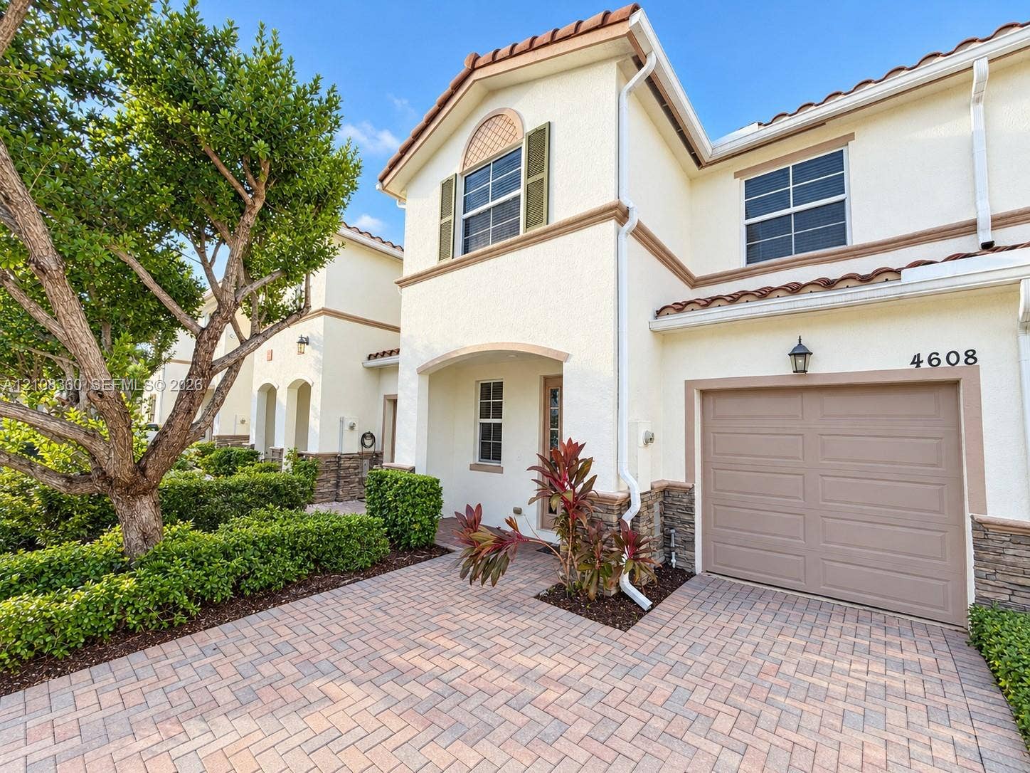 4608 Tara Cove Way, #4608, West Palm Beach, West Palm Beach, FL 33417 Stucco exterior featuring decorative stone veneer accents, arched entryway, paved driveway, and tile roofline