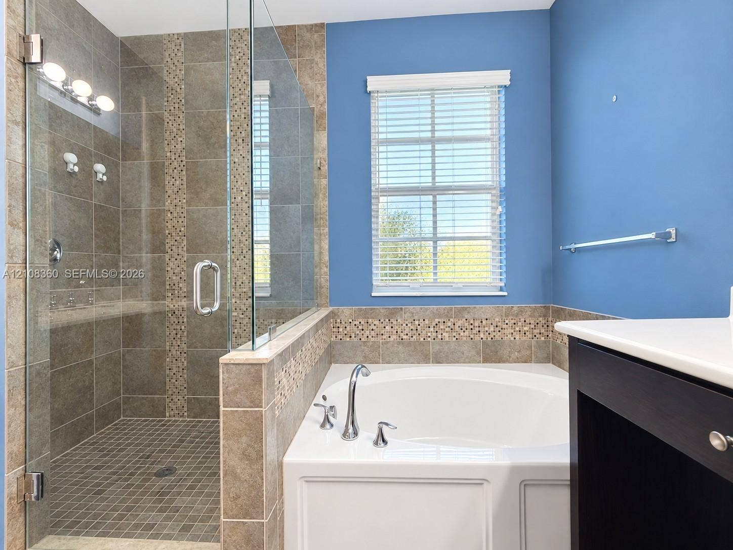 4608 Tara Cove Way, #4608, West Palm Beach, West Palm Beach, FL 33417 Walk-in shower with glass enclosure, soaking tub with deck-mounted faucet, tile surround with mosaic accent detailing, and dark-finish vanity