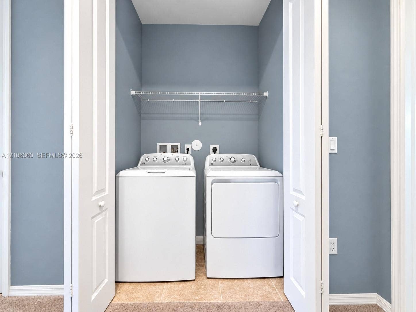 4608 Tara Cove Way, #4608, West Palm Beach, West Palm Beach, FL 33417 Laundry closet featuring bifold doors, tile flooring, and integrated wire shelving