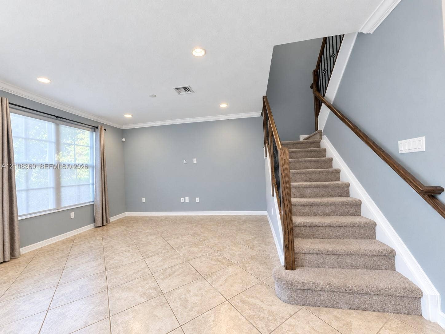 4608 Tara Cove Way, #4608, West Palm Beach, West Palm Beach, FL 33417 Open interior space featuring neutral tile flooring, recessed lighting, crown molding, and a staircase with a wooden handrail and metal balusters