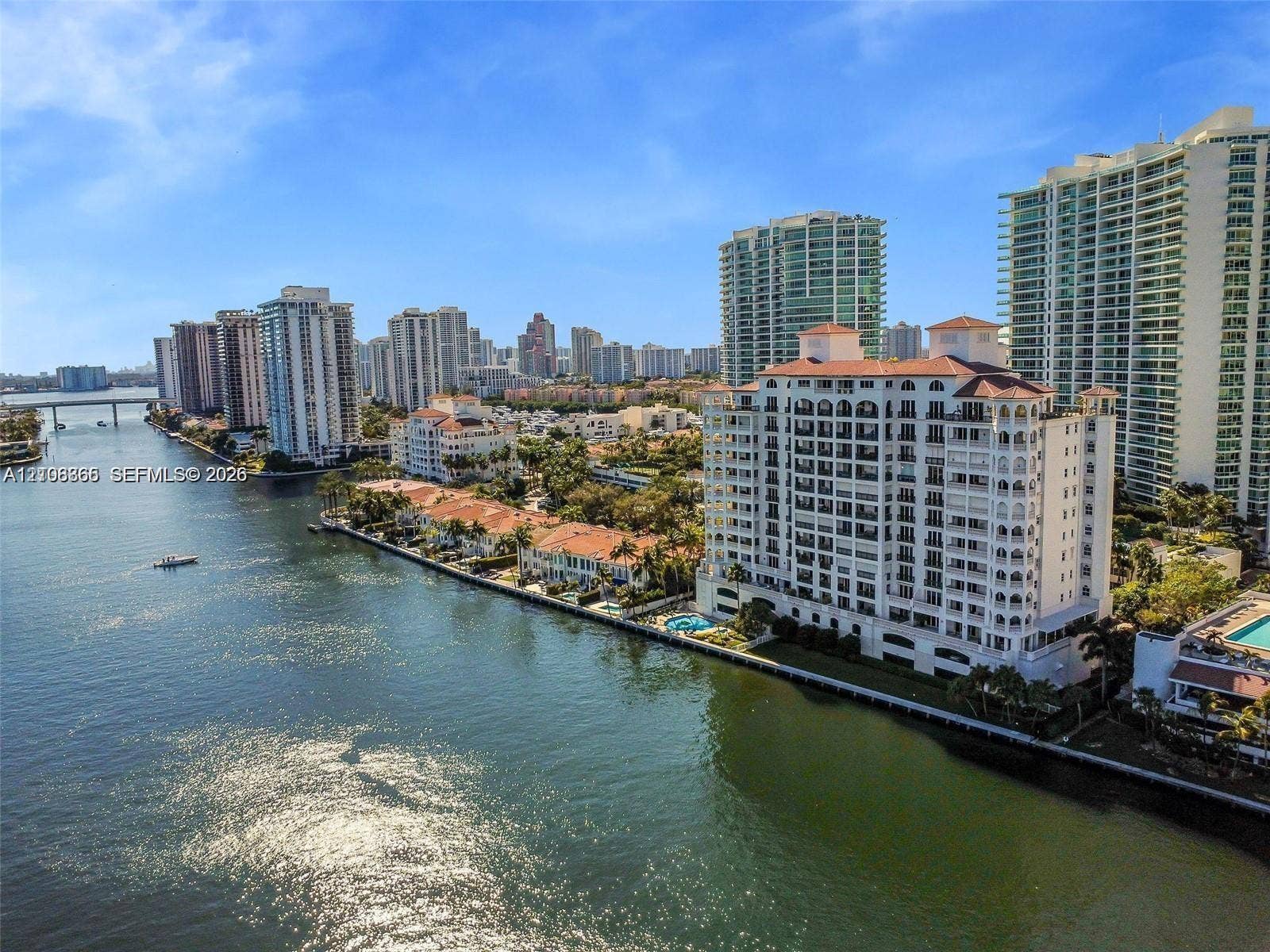 20165 NE 39 Place, #403, Aventura, FL 33180 Waterfront high-rise building featuring a red-tiled roof, multi-level balconies, and a ground-level swimming pool
