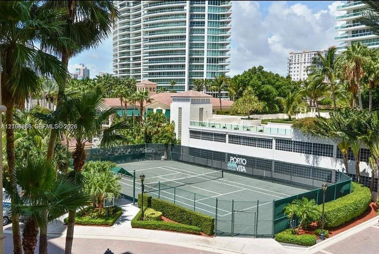 20165 NE 39 Place, #403, Aventura, FL 33180 Tennis court facility featuring a fenced perimeter, hard surface, integrated lighting, and manicured landscaping