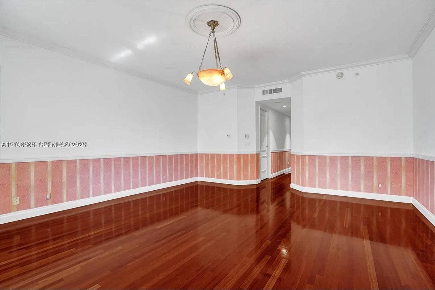 20165 NE 39 Place, #403, Aventura, FL 33180 Interior space featuring high-gloss wood-finish flooring, decorative wall wainscoting, and a central ceiling medallion with a multi-arm light fixture