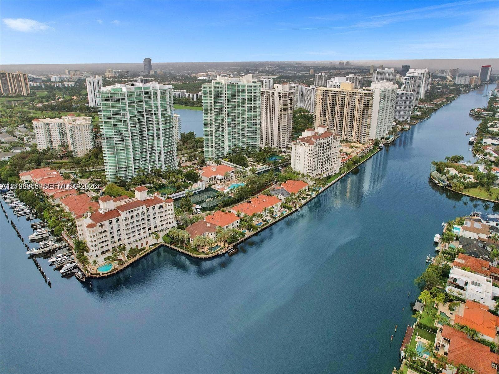 20165 NE 39 Place, #403, Aventura, FL 33180 Aerial perspective of waterfront high-rise residential buildings featuring private dockage, clay tile roofing, and expansive water frontage