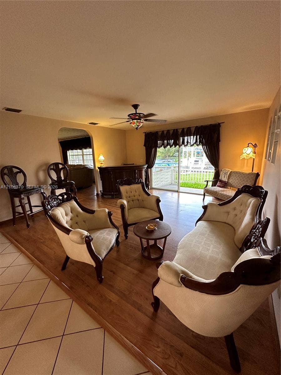 18901 SW 63rd Street, Southwest Ranches, FL 33332 Raised wood-finish flooring, tile flooring, arched wall opening, and sliding glass doors