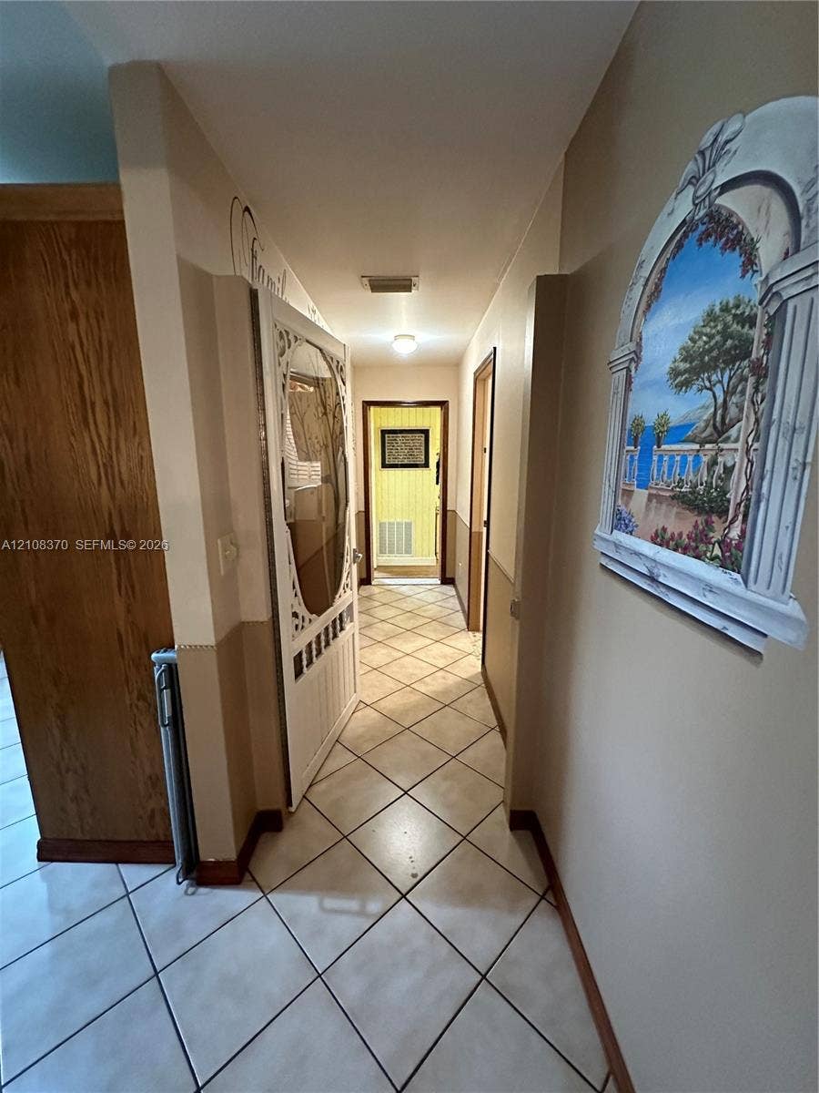 18901 SW 63rd Street, Southwest Ranches, FL 33332 Ceramic tile flooring laid in a diagonal pattern, wood-finish interior doors, and neutral wall tones with decorative wall molding
