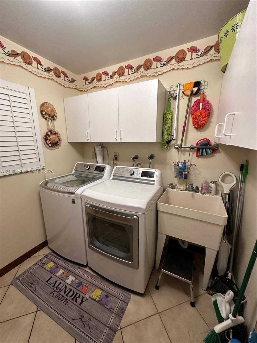 18901 SW 63rd Street, Southwest Ranches, FL 33332 Laundry area featuring white cabinetry, a freestanding utility sink with faucet, ceramic tile flooring, and plantation shutter window coverings