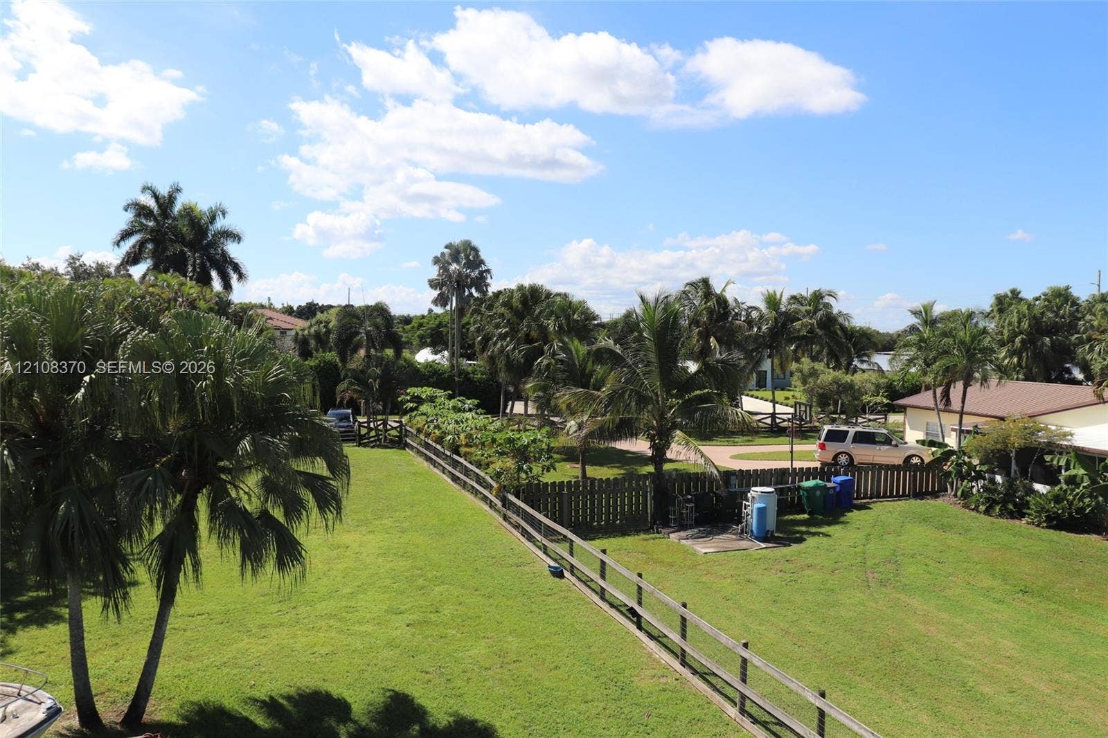 18901 SW 63rd Street, Southwest Ranches, FL 33332 Expansive grassy lot featuring mature palm trees and perimeter wood-rail fencing