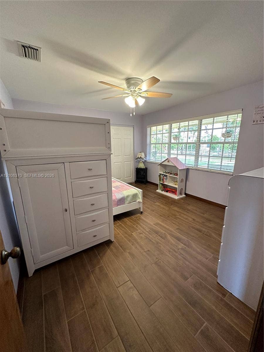 18901 SW 63rd Street, Southwest Ranches, FL 33332 Wood-finish flooring, multi-pane window with grid pattern, and ceiling fan with integrated lighting