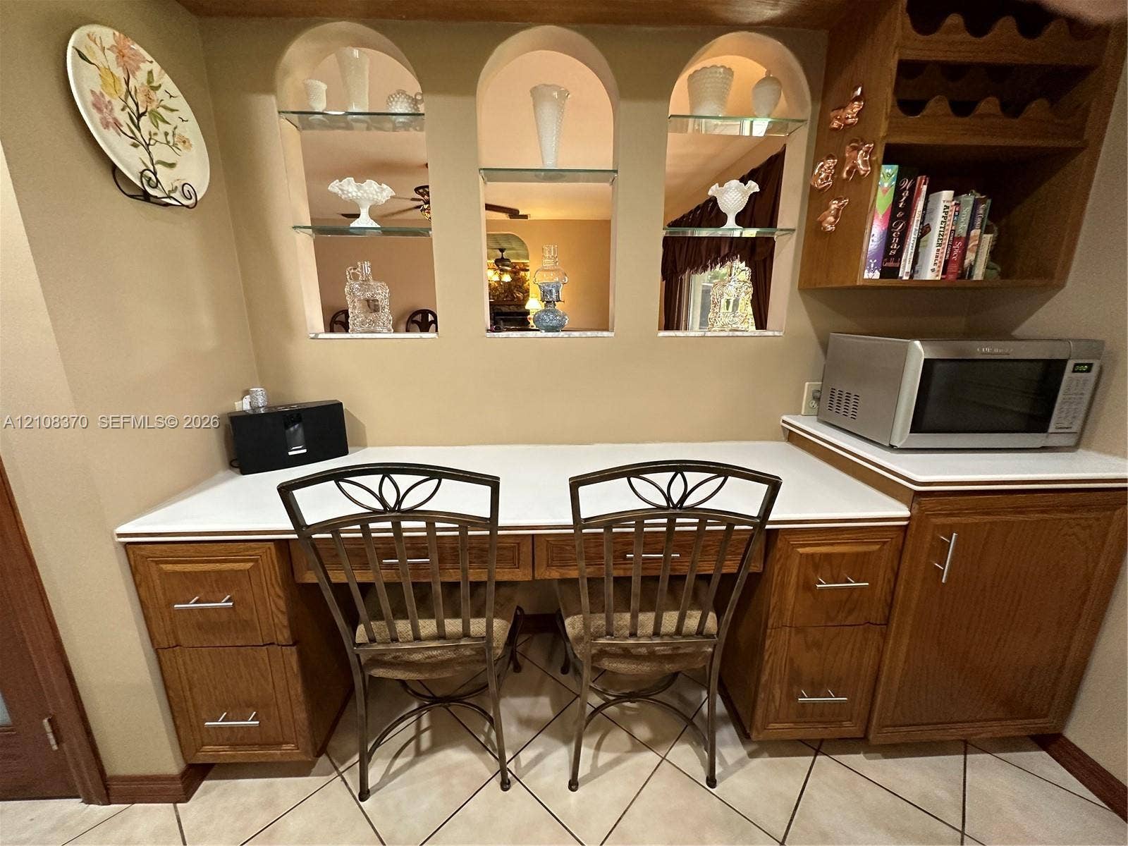18901 SW 63rd Street, Southwest Ranches, FL 33332 Built-in wood cabinetry featuring brushed nickel hardware, expansive solid-surface countertop, three arched display niches with glass shelving, and integrated wine storage