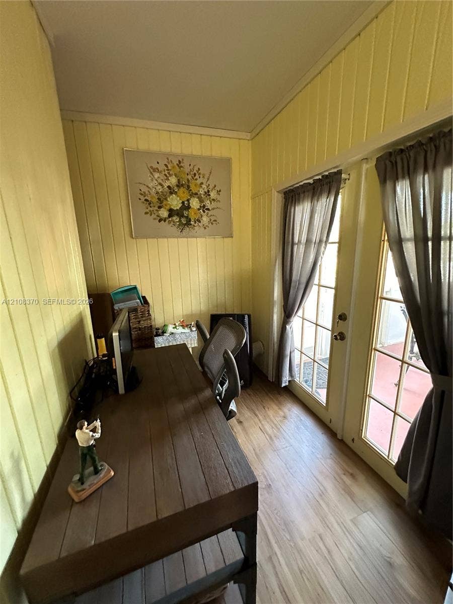 18901 SW 63rd Street, Southwest Ranches, FL 33332 Vertical wood-paneled walls, wood-finish flooring, and double glass-paned doors providing exterior access
