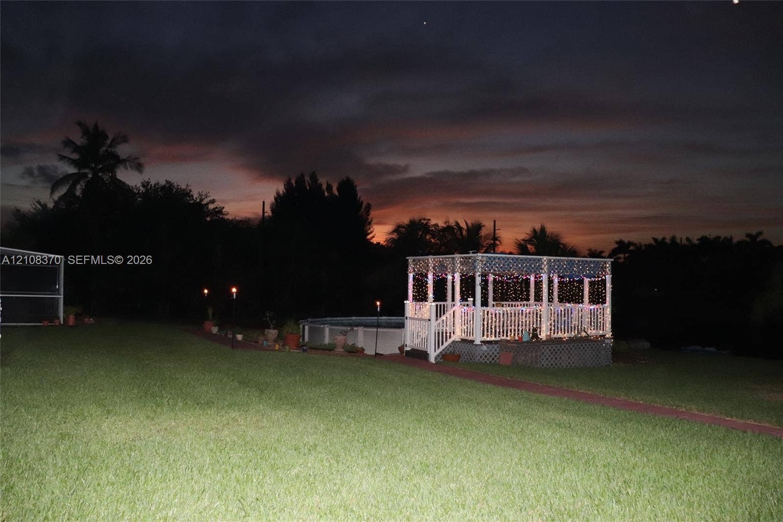 18901 SW 63rd Street, Southwest Ranches, FL 33332 Backyard area featuring an elevated wooden gazebo, an above-ground pool, and a manicured lawn